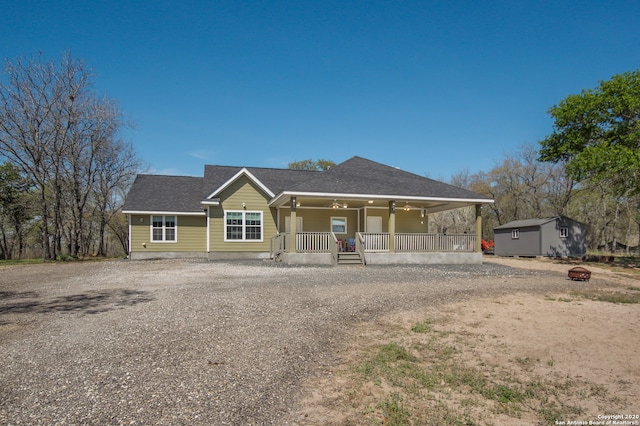 view of front facade featuring ceiling fan and a storage shed