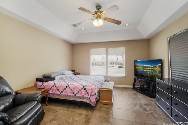 bedroom featuring a tray ceiling, tile patterned floors, and ceiling fan