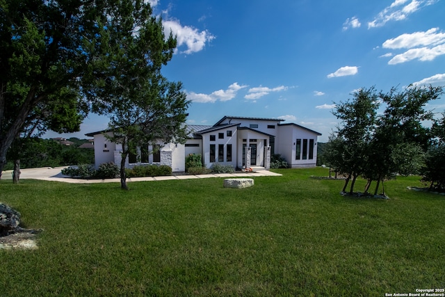 view of front facade with french doors, a front yard, and stucco siding