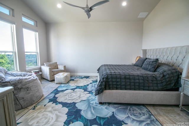 bedroom with ceiling fan, vaulted ceiling, and light hardwood / wood-style flooring