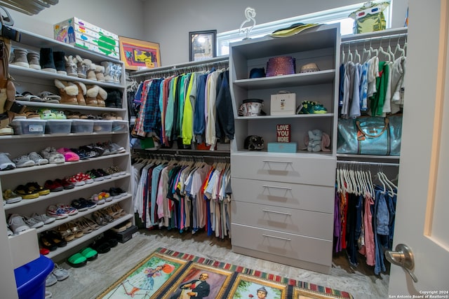 walk in closet with light hardwood / wood-style floors