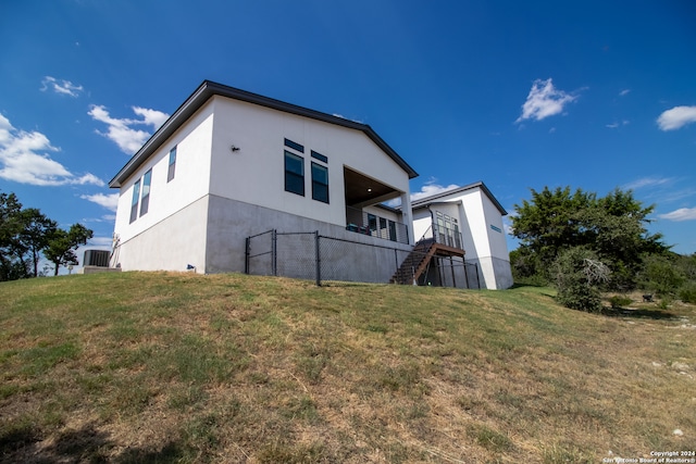 back of property featuring a yard and a wooden deck