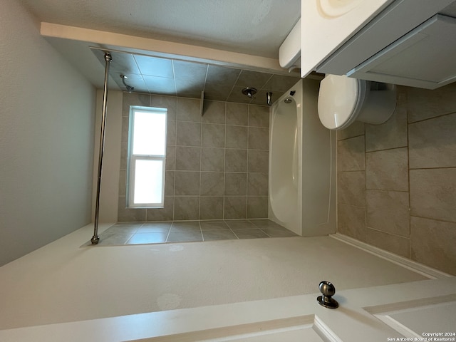 bathroom featuring toilet and a tile shower