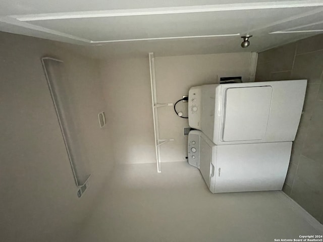 clothes washing area featuring stacked washer and dryer