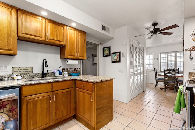 kitchen with range, light stone countertops, ceiling fan, sink, and light tile patterned flooring