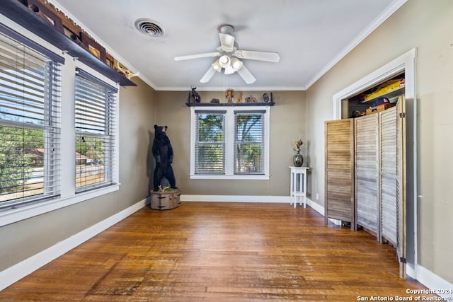 empty room with ornamental molding, hardwood / wood-style flooring, and ceiling fan