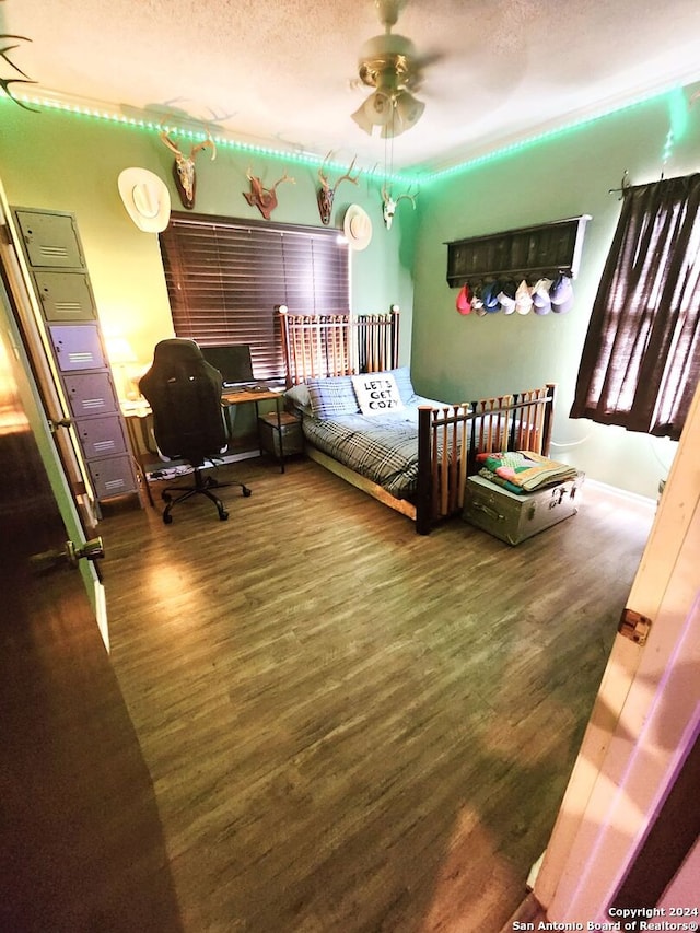 bedroom with ceiling fan, dark hardwood / wood-style floors, and a textured ceiling