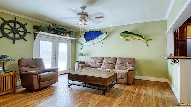 living room featuring french doors, light wood-type flooring, ornamental molding, and ceiling fan