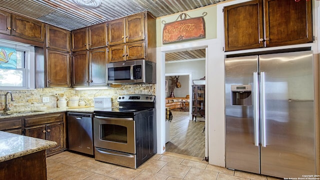 1801 3rd St, Floresville, TX 78114 - kitchen with appliances with stainless steel finishes, a sink, tasteful backsplash, and light stone countertops