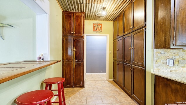 kitchen featuring light stone countertops and backsplash