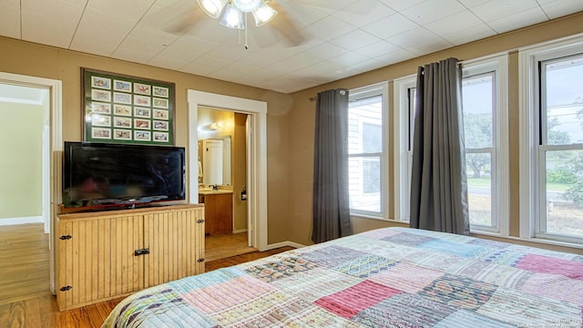 1801 3rd St, Floresville, TX 78114 - bedroom featuring multiple windows, light wood-style floors, and baseboards