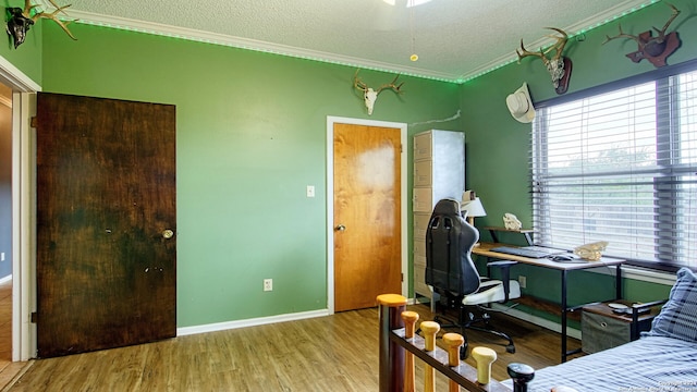 bedroom with ornamental molding, a textured ceiling, and light hardwood / wood-style floors