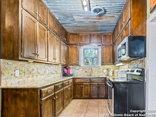 kitchen with range with electric stovetop, tasteful backsplash, sink, and light tile patterned floors