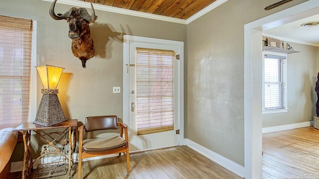 living area featuring crown molding, baseboards, wood finished floors, and visible vents