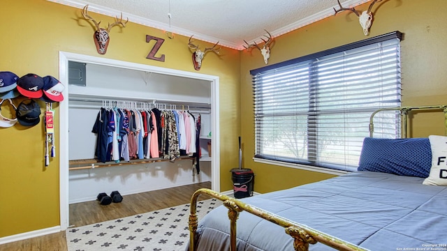 bedroom with a closet, multiple windows, hardwood / wood-style flooring, and ornamental molding