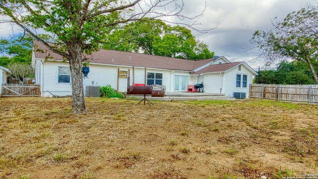 1801 3rd St, Floresville, TX 78114 - back of property with a fenced backyard, central AC unit, french doors, and a patio area