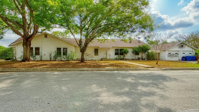 single story home featuring a garage and an outbuilding