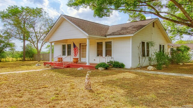 1801 3rd St, Floresville, TX 78114 - view of front of home with roof with shingles, covered porch, and fence