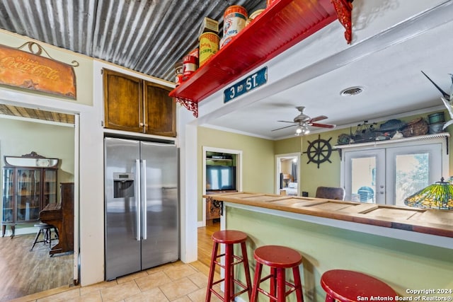 kitchen featuring french doors, ornamental molding, stainless steel fridge, ceiling fan, and light hardwood / wood-style flooring