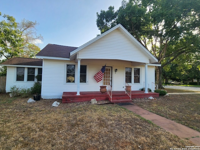 view of front of house featuring covered porch and a front yard