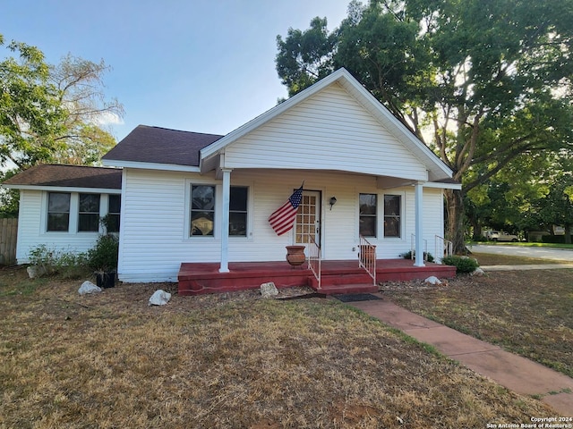 1801 3rd St, Floresville, TX 78114 - view of front facade with covered porch, roof with shingles, and a front lawn