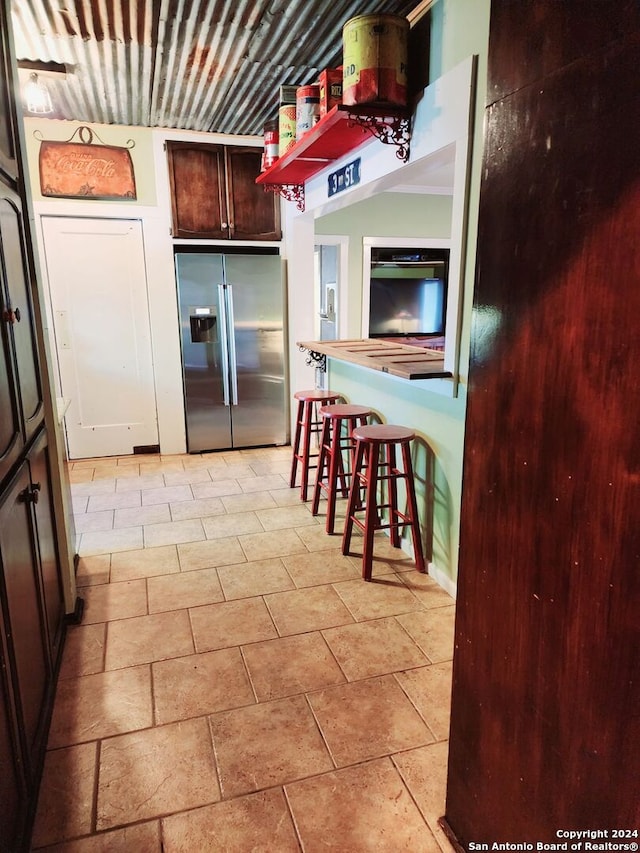 1801 3rd St, Floresville, TX 78114 - kitchen featuring stainless steel fridge with ice dispenser and dark brown cabinets