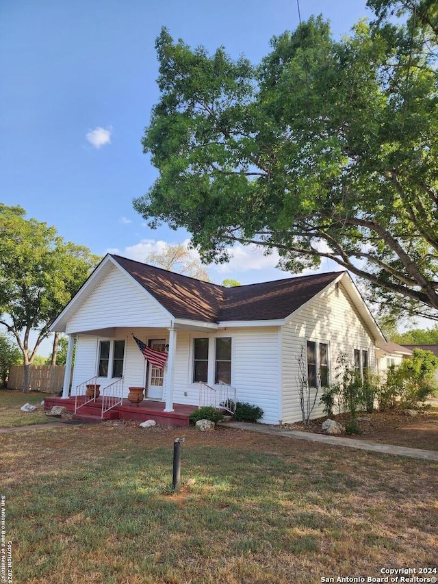 single story home with a front yard and a porch