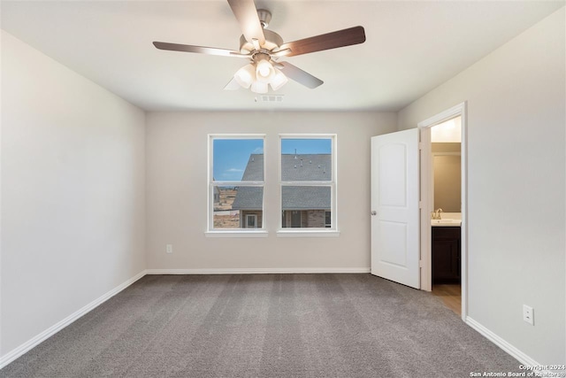 unfurnished room with sink, ceiling fan, and carpet flooring