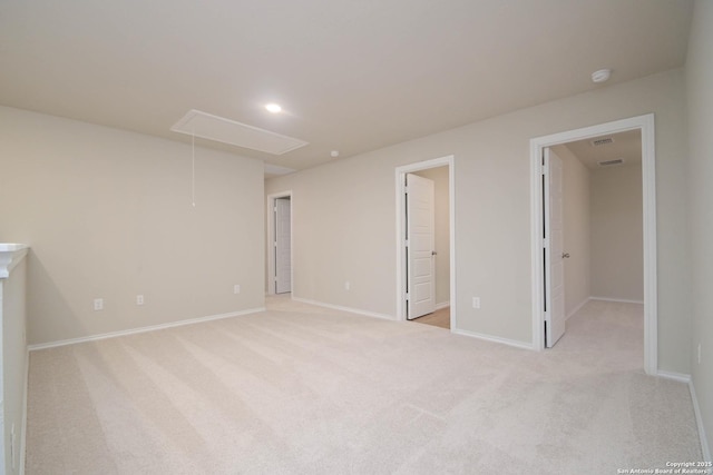 unfurnished bedroom with ensuite bathroom, a walk in closet, and light colored carpet