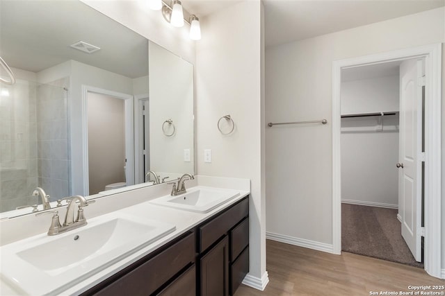 bathroom with walk in shower, vanity, toilet, and hardwood / wood-style floors