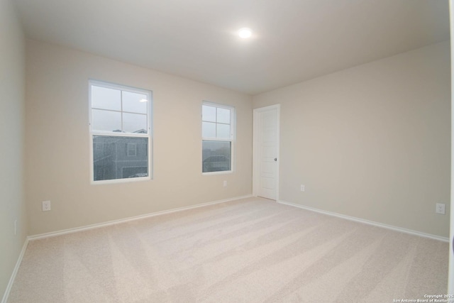 unfurnished room featuring light carpet