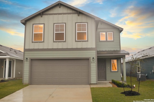 front facade with a garage and a lawn