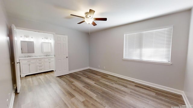 unfurnished bedroom with light hardwood / wood-style floors, ensuite bath, sink, and ceiling fan