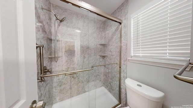 bathroom with an enclosed shower and toilet