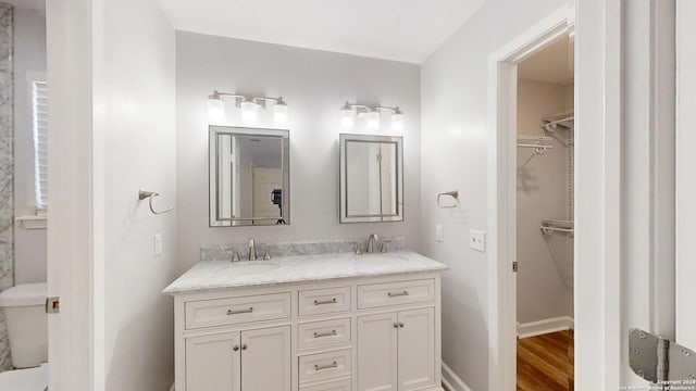 bathroom featuring wood-type flooring, vanity, and toilet