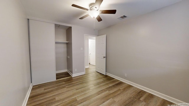 unfurnished bedroom featuring wood-type flooring, a closet, and ceiling fan