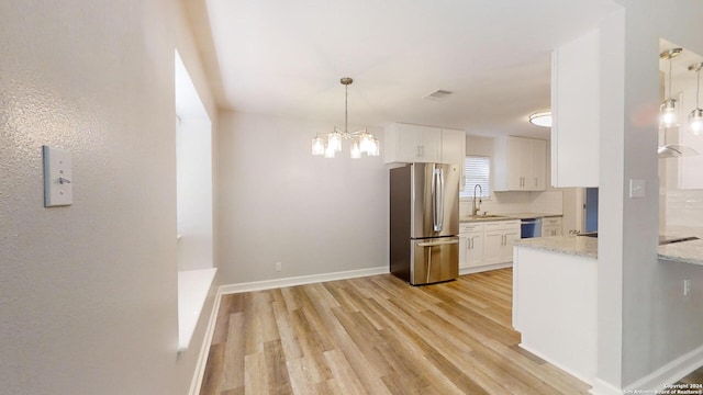 kitchen with white cabinets, light hardwood / wood-style floors, stainless steel appliances, and sink