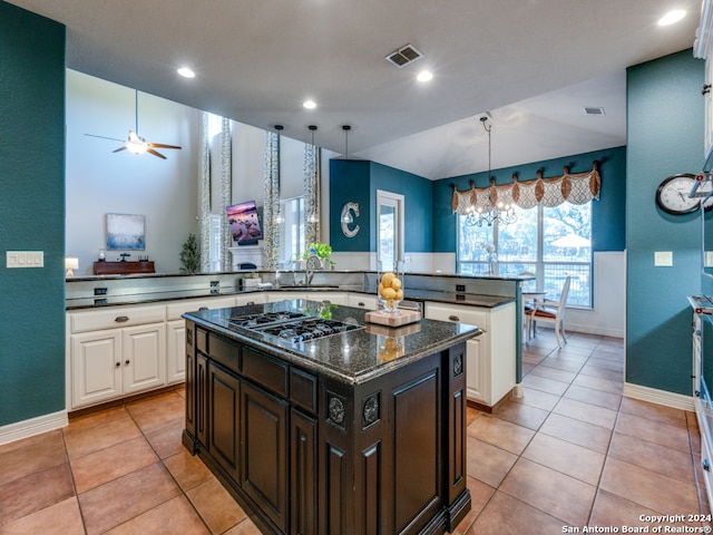 kitchen featuring white cabinetry, sink, a kitchen island, and stainless steel gas stovetop