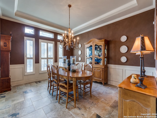 dining area with ornamental molding, a chandelier, and a tray ceiling