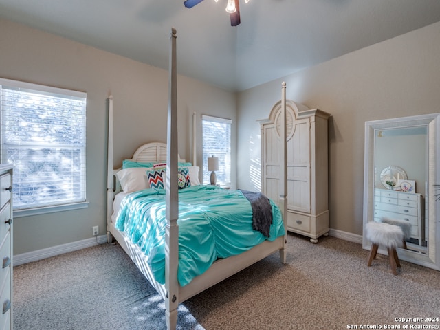 carpeted bedroom with ceiling fan, vaulted ceiling, and multiple windows