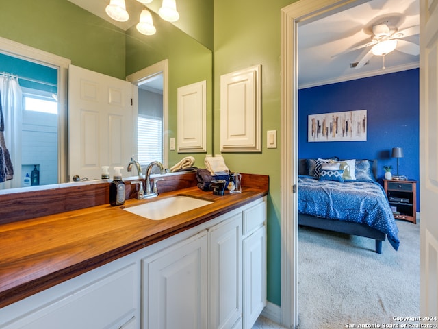 bathroom with vanity, ceiling fan, and ornamental molding