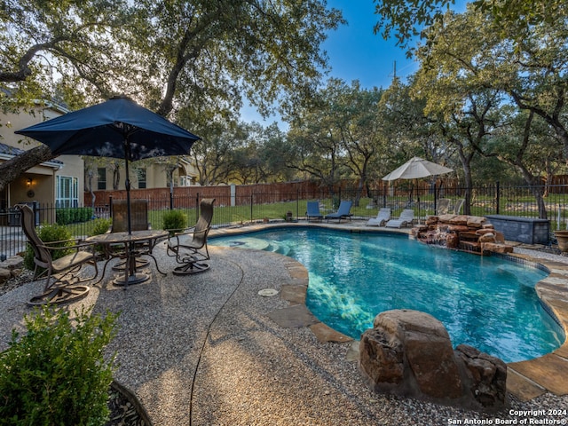 view of swimming pool featuring pool water feature and a patio