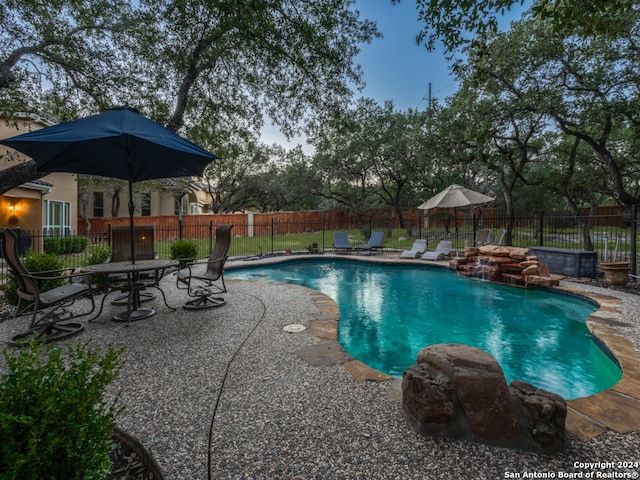 view of pool featuring pool water feature and a patio