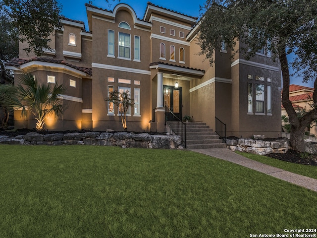 mediterranean / spanish house featuring a front yard