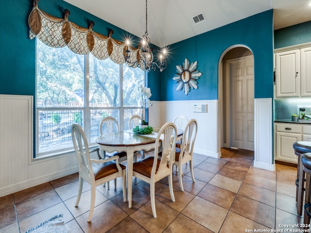 tiled dining area with an inviting chandelier