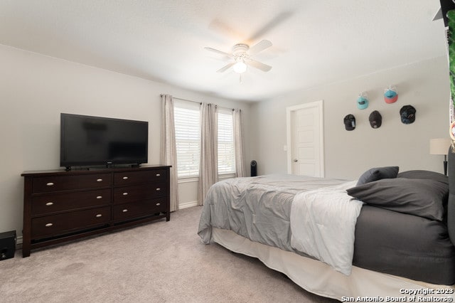 bedroom with ceiling fan and light colored carpet