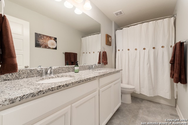 full bathroom with vanity, shower / tub combo, and toilet