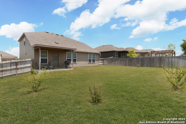 back of property featuring a yard and a patio