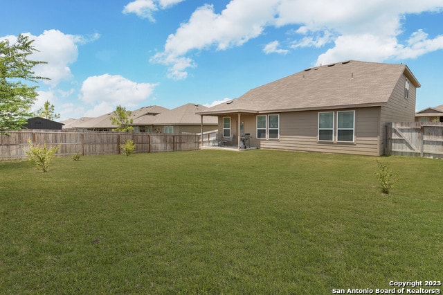 rear view of property featuring a lawn