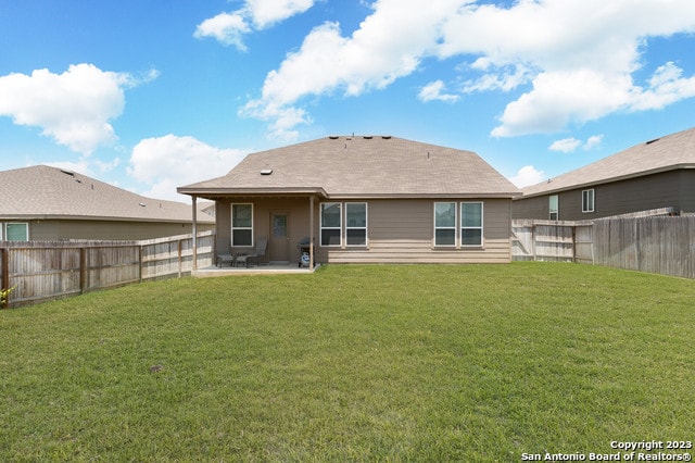 back of house with a yard and a patio area